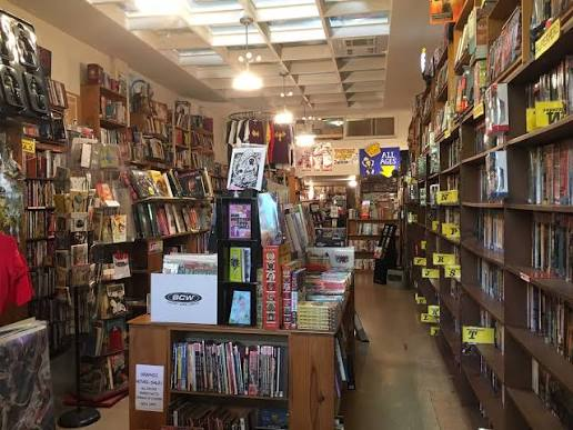 Inside my local comic book store, with shelves of comics and a cozy browsing aisle